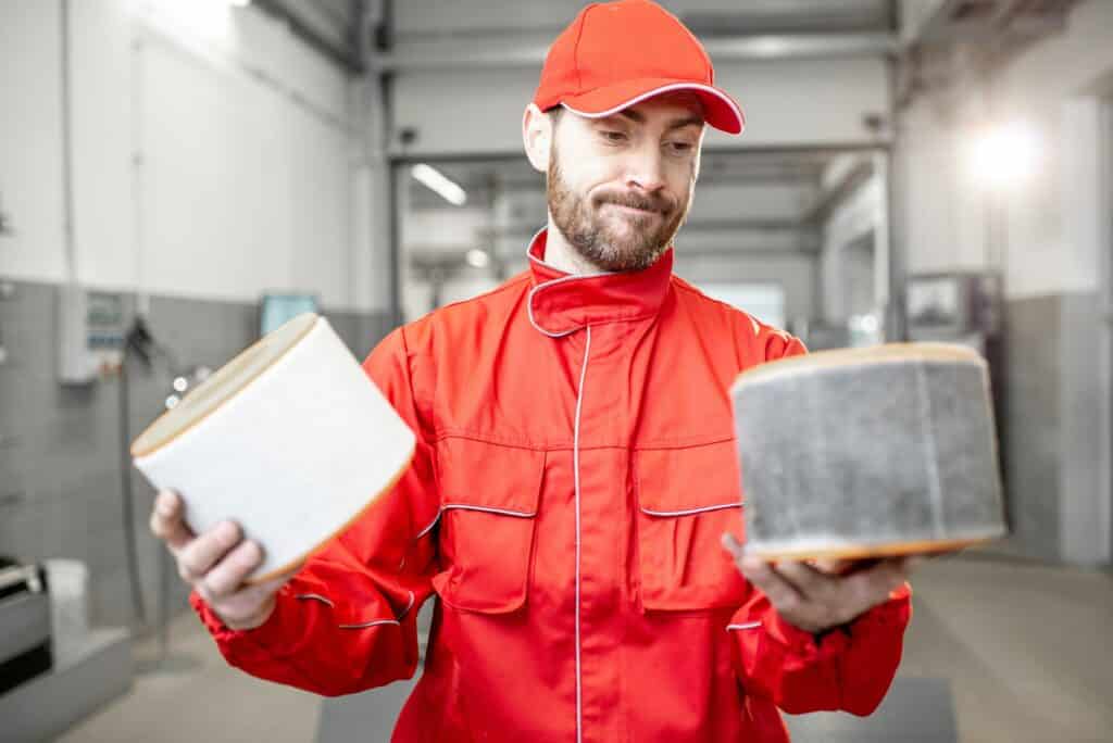 Auto mechanic with new and used car air filter